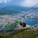 A cable car gondola descending over a coastal town surrounded by mountains